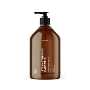 Eine braune Kunststoff-Pumpenflasche mit der Aufschrift DALUMA STRENGTHENING HAIR WASH und weißem Text hat ein minimalistisches Design und eine schwarze Pumpe, fotografiert auf Weiß. Die Rezeptur unterstützt das Haarwachstum und verleiht dem Haar Glanz.