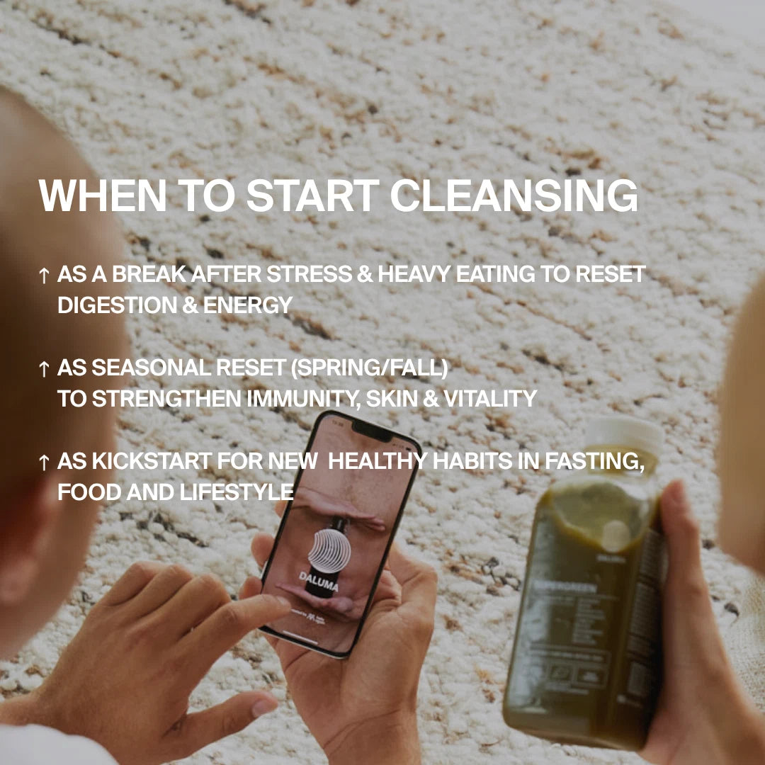 Eine Person sitzt auf einem hellen Teppich und hält eine grüne DALUMA BESSERE SAFTKUR - 7 TAGE Saftflasche und ein Telefon mit einer Reinigungs-App. Der Text hebt Gründe für eine Reinigung hervor, z. B. nach Stress, zu bestimmten Jahreszeiten oder um gesunde Gewohnheiten zu fördern.