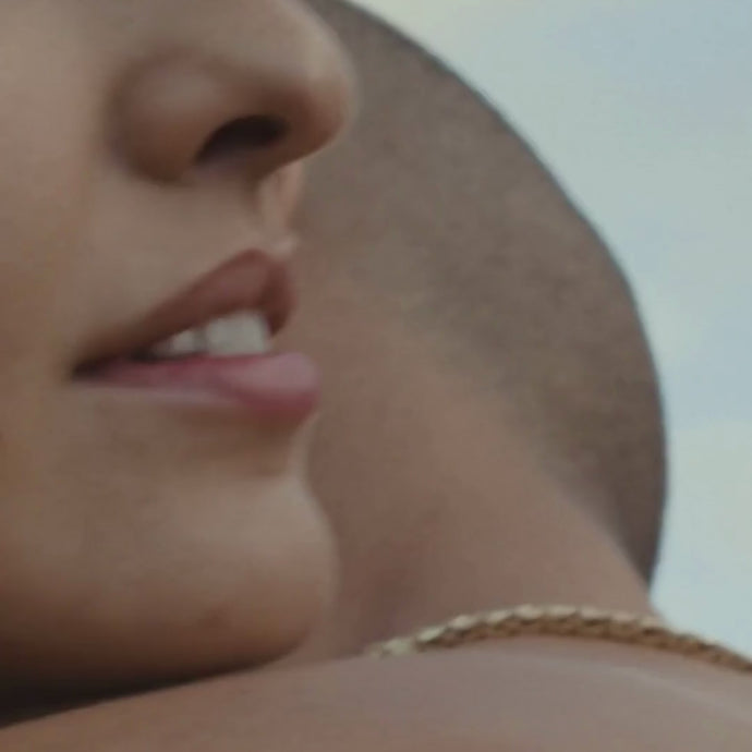 Nahaufnahme zweier Menschen, die sich umarmen: Einer lächelt sanft in die Kamera, während der Rücken des anderen und eine Goldkette zu sehen sind. Unscharfer Hintergrund. Daluma HEALTH CLUB PRO MEMBERSHIP ist abgebildet.