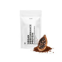 Ein weißer DALUMA VEGANES PERFORMANCE PROTEIN KAKAO-Beutel steht aufrecht neben einer halbierten Kakaoschote, Kakaobohnen und rohem Kakao auf weißem Hintergrund und hebt hochwertiges veganes Protein hervor.